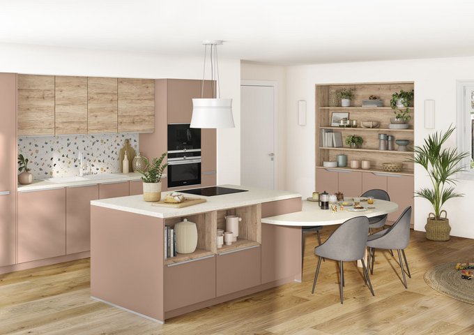 Cocina moderna con gabinetes rosados, encimera central con estufa